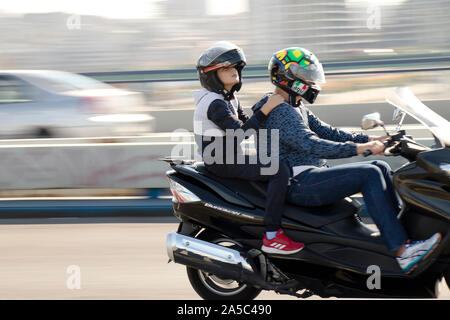 Belgrad, Serbien - Oktober 16, 2019: Der junge Mann und ein Junge reitet auf einem Motorrad über die Stadt Street Bridge Stockfoto