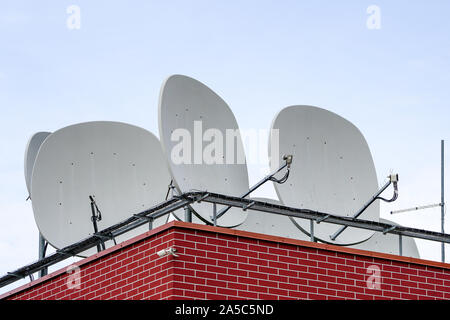 Viele weiße Parabol Satelliten antena Gerichte auf dem Dach des Hauses Stockfoto