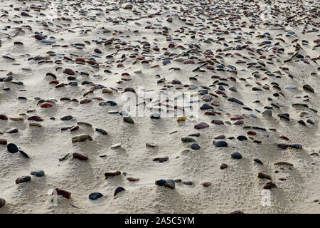 Sandstrand mit vielen kleinen Steinen, schöner Hintergrund Stockfoto