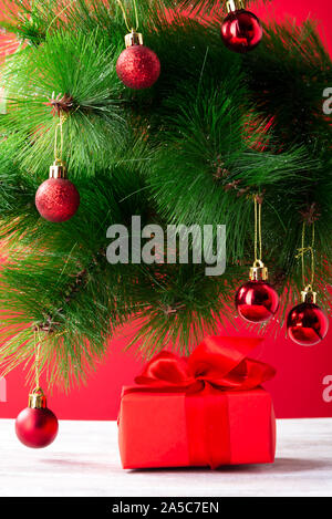 Geschenk rotes Kästchen mit einem roten Bogen unter dem Baum, Weihnachten Zusammensetzung Stockfoto