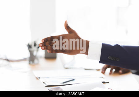 Zugeschnittenes Bild der afrikanischen Investor seine Hand zur Verlängerung Stockfoto
