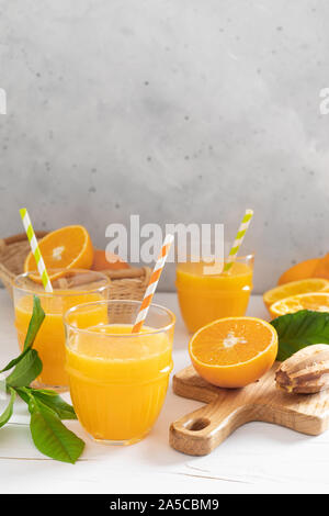 Orangensaft. Frisch gepresster Saft in Gläser und frische Früchte mit Blätter Stockfoto