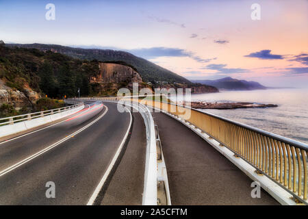 Grand Pacific Drive von Sydney nach Wollongong über Sea Cliff Brücke nach Norden, malerische Küste von Australian Pacific ocean bei Sonnenaufgang mit unscharfen passi Stockfoto