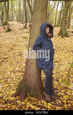 18. Oktober 2019, Rheinland-Pfalz Kümbdchen: Wald Bademeister Michaela Konrad lehnt sich gegen einen Baum. Waldbaden boomt auch in Rheinland-Pfalz. Die Achtsamkeit Übungen machen den Unterschied zu den klassischen Wald. (Zu dpa' werfen Blätter von hoher Qualität - Wald Baden wird Trend - Arzneimittel und Wellness Wald geplant") Foto: Thomas Frey/dpa Stockfoto