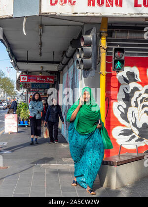 Die islamische Frau, tragen, Hijab zu Fuß, während Sie auf einem mobilen Telefon entlang der Victoria Street Richmond, Melbourne, Victoria, Australien. Stockfoto