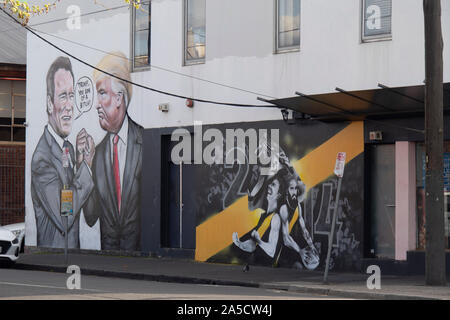 Wandbild von Arnold Schwarzenegger und Donald Trump in einen Arm neben Wandgemälde von Richmond Football Club Tiger Richmond Melbourne Australien ringen. Stockfoto