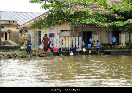 Alleppey, kerala, indien - Südostasien; nach dem Mittagessen indische Schule Kinder waschen ihr Schiff in Backwater Munroe Island im ländlichen Dorf. Stockfoto