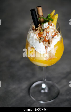Bio Mango und Passionsfrucht tropische Eisbecher in Wein Glas Stockfoto