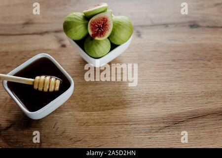 Feigen und Honig in einer weißen Schüssel auf Holz- Hintergrund Stockfoto