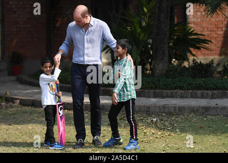 Der Herzog von Cambridge trifft junge Kinder während Kricket spielen am Freitag bei einem Besuch im SOS Kinderdorf in Lahore in Pakistan. Stockfoto