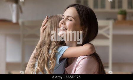 Lächelnde Mutter umarmen kleine Tochter, Liebe auszudrücken und Support Stockfoto