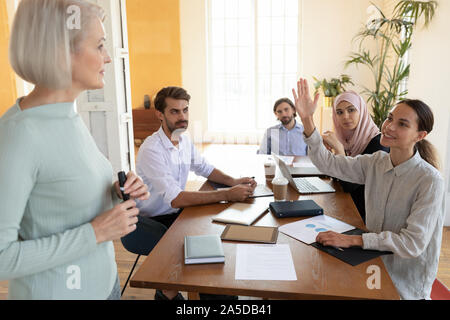 Junge Geschäftsfrau training Teilnehmer Heben der Hand alte Fragen mentor Frage Stockfoto