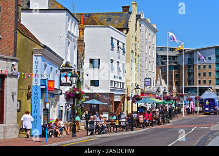 Die Leute draußen sitzen die bunten Bars & Cafés, in der Sonne, mit Blick auf den Hafen von Poole. Die Portsmouth Hoy und die Poole Arme sind nur zwei. Stockfoto