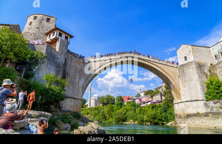 Touristen Ziel Kameras als Bosnische diver Sprung in den Fluss Neretva aus der Stari Most, Alte Brücke von Mostar, Bosnien und Herzegowina, Europa, 2019. Stockfoto