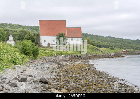 Südlich der historischen mittelalterlichen Trondenes Kirche, von Fjord Ufer unter Hell bewölkt Licht in Harstad, Hinnoya, Vesteralen, Norwegen Schuß Stockfoto