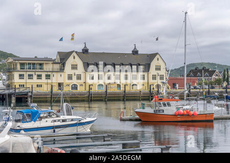 HARSTAD, Norwegen - 12. Juli 2019: Polarkreis fjord Stadtbild der kleinen Stadt Hafen mit alten Gebäuden und Angelegte Boote, unter hellen trübe Licht schoß Stockfoto