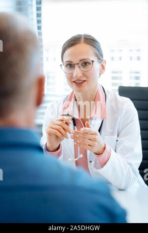 Schöne Arzt mit männlichen Patienten in Ihrem Büro Stockfoto
