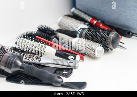 Verschiedene Bürsten und Kämme auf einem weißen Tisch im Beauty Salon. Professionelle Friseur tools. Beauty- und Friseursalon Konzept. Stockfoto