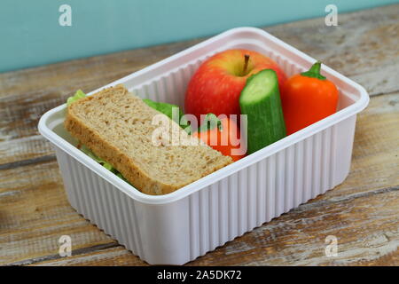 Gesundes Lunchpaket mit braunen Käse Sandwich, knackige Paprika, frische Gurke und Apfel Stockfoto