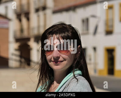 Porträt einer Plus size Junge brünette Frau mit Brille auf der Straße Hintergrund an einem sonnigen Tag Stockfoto