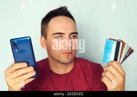 Near Field Communication. Hand Banknoten Kreditkarten und Telefon. Die Auswahl der Smartphone als Methode der Kauf und die Bezahlung der Ware. Stockfoto