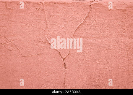 Textur einer lackiert rosa Wand mit Rissen. Verputzte Betonwand. Zusammenfassung Hintergrund. Stockfoto