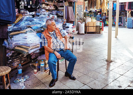 Ankara, Türkei - Oktober, 2012: Türkische Verkäufer vor seinem Kleid Shop auf dem Markt in Ulus, Ankara, Türkei sitzen. Editorial. Stockfoto