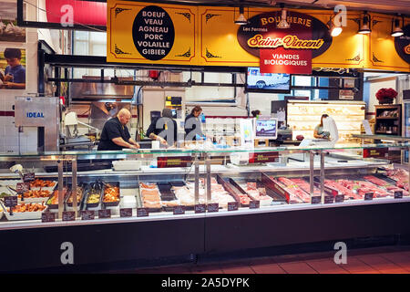 Kanadische Arbeiter schneiden und Zubereitung von Fleisch hinter der Theke bei Saint Vincent Metzgerei shop Atwater Market in Montreal Stockfoto