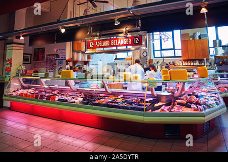 Kanadische Arbeiter schneiden und Zubereitung von Fleisch hinter dem Zähler bei adelard Belange Metzgerei in Atwater Market in Monteal, Kanada Stockfoto