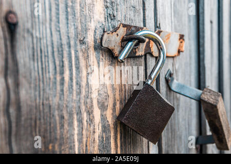 Ein offenes Vorhängeschloss am Tor von einem alten Dorf Scheune Stockfoto