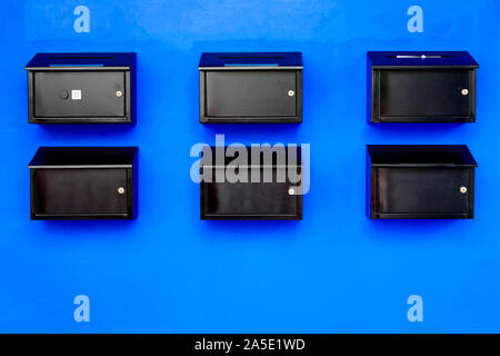 Farbe schwarz mail Box auf der blauen Wand Stockfoto