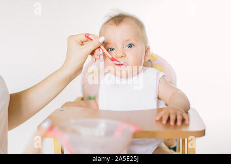 Mutter Kind füttern. Erste feste Nahrung für junge Zicklein. Gesunde Ernährung für Kinder. Eltern füttern die Kinder Stockfoto