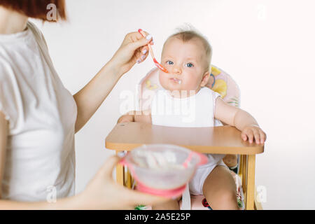 Mutter Kind füttern. Erste feste Nahrung für junge Zicklein. Gesunde Ernährung für Kinder. Eltern füttern die Kinder Stockfoto