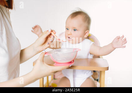 Mutter Kind füttern. Erste feste Nahrung für junge Zicklein. Gesunde Ernährung für Kinder. Eltern füttern die Kinder Stockfoto