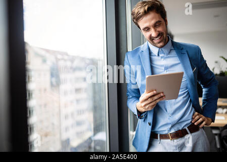 Porträt der Geschäftsmann lächelnd bei der Verwendung von digital-Tablette Stockfoto