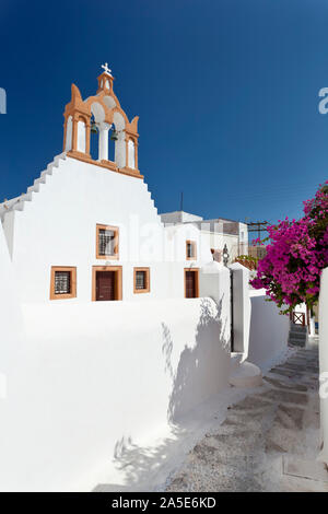 Eine Kirche in Emborio mit bunten Bougainvillea in Santorini. Stockfoto