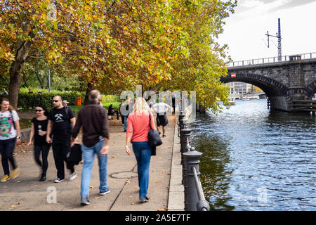 20. Oktober 2019, Berlin: Menschen Spaziergang entlang der Spree bei mildem und sonnigem Wetter in James Simon Park. Foto: Paul Zinken/dpa Stockfoto