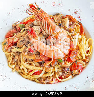 Weiße Platte mit Linguini und Garnele auf strukturierte Holztisch. Stockfoto