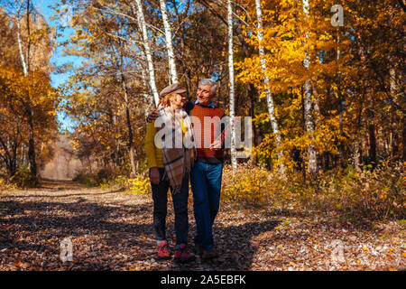 Herbst Spaziergang. Senior Paar im Herbst park Natur bewundern. Glücklich der Mann und die Frau zu reden und Entspannen im Freien Stockfoto