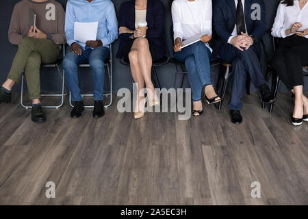 Multiethnischen business Leute sitzen auf Stühlen, Beine Nähe zu sehen. Stockfoto