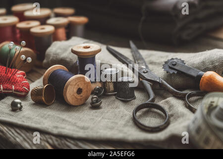 Vintage sewing Items: retro Tailoring Schere, Maßband, Fingerhut, Holz- Spulen des Gewindes, Messer, Kissen für einschließlich Pins, Nadeln ein Stockfoto