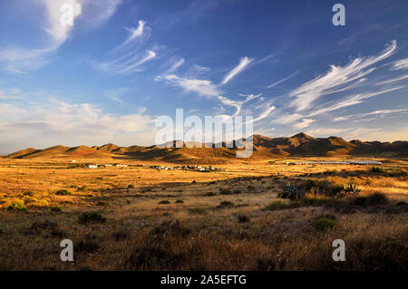 Sonnenuntergangslandschaft der Stadt Boca de los Frailes und nahe gelegene Gewächshäuser und Hügel im Naturpark Cabo de Gata-Níjar (Boca de los Frailes, Almeria, Spanien) Stockfoto