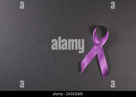 Purple ribbon auf schwarzem Hintergrund. Symbol der Epilepsie Bewusstsein Stockfoto