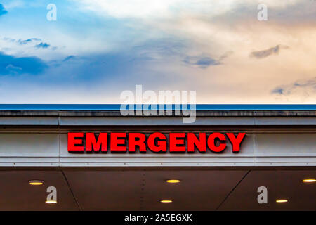 Die Zeichen im Block Schriftzüge auf den Überhang über ein Drop-off leuchtet Auffahrt außerhalb eines Krankenhauses liest "Notfall". Stockfoto