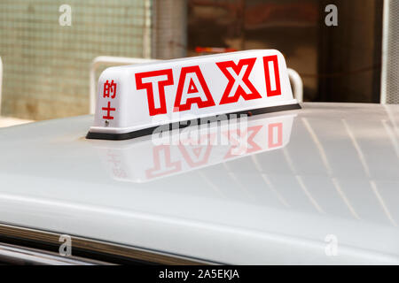 Rote taxi Schild auf dem Dach eines Taxis in Hongkong im Tageslicht. Englisch auf der Rückseite, chinesische Zeichen auf der Seite. Stockfoto