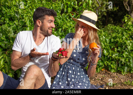 Junges Paar Scherzen auf Picknick in der Natur Stockfoto