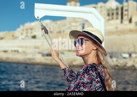 Junge blonde 20s Frau mediterrane Destination am Meer Anreise aufgeregt Stockfoto