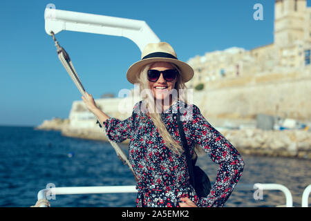 Glückliche junge 20s Blonde reisenden Frau zum Ziel am Mittelmeer ankommen Stockfoto