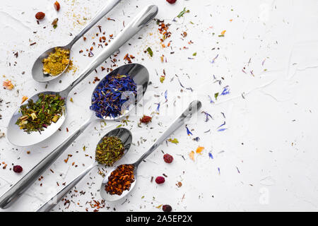 Vielzahl von getrockneten Tee, getrocknete Kräuter, Grün und Früchte Tee auf Löffel über weißen Hintergrund mit kopieren. Stockfoto