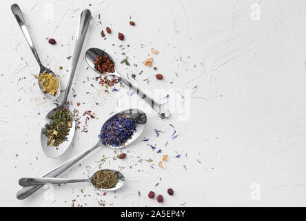 Vielzahl von getrockneten Tee, getrocknete Kräuter, Grün und Früchte Tee auf Löffel über weißen Hintergrund mit kopieren. Stockfoto